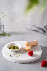 Green Matcha and savoyardi for Tiramisu Dessert, raspberry on gray concrete background. Superfoods, healthy nutrition. Close up. Copy space