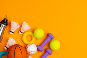 Assortment of sport equipment on yellow background, top view