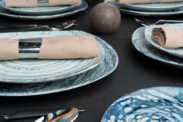 Table setting. Plates with abstract pattern on black table