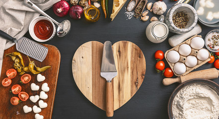 woman preparing a festive dinner for two in honor of Valentine's Day classic Italian pizza Margherita in the shape of a heart and mozzarella in the shape of a heart