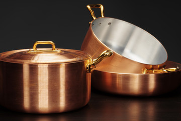 Set of copper cookware over dark background