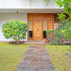 contemporary house garden with stone path to the wooden entrance door, Athens Greece