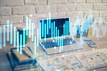 Stock market chart hologram drawn on personal computer background. Double exposure. Concept of investment.