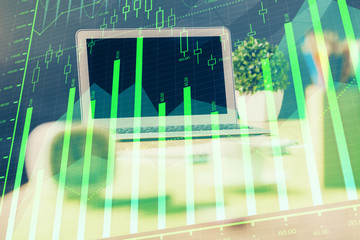 Stock market chart hologram drawn on personal computer background. Double exposure. Concept of investment.