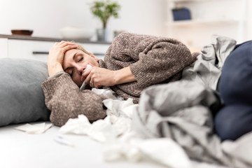 Woman sick in the bed, flu and virus infections, allergy, seasonal healt issues.