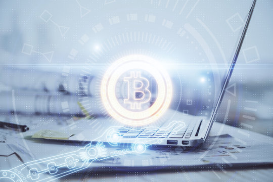 Double exposure of blockchain theme hologram and table with computer background. Concept of bitcoin crypto currency.