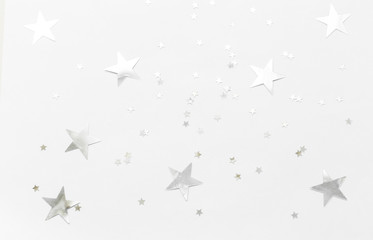 Silver confetti and stars and sparkles on a light background. Top view, flat lay. Copy text. holiday background. For Christmas, New Year, Valentine's Day
