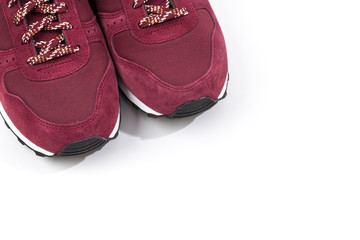 a pair of new burgundy, cherry sneakers or athletic shoes isolated on a white background.
