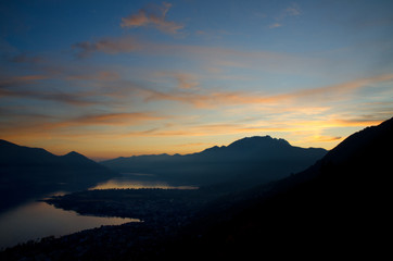Dusk over an Alpine Lake Maggiore with Orange Clouds in Ticino, Switzerland.