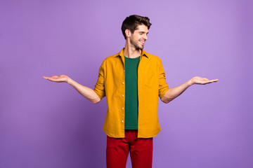 Photo of cheerful white man holding two objects empty space with hands smiling toothily isolated violet color pastel background