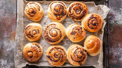 Top view sweet homemade cinnamon rolls with chocolate cream on a baking sheet