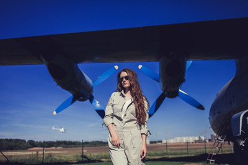 military strong woman in uniform and sunglasses on the background of the plane's blades