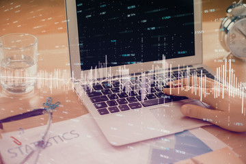 Multi exposure of market chart with man working on computer on background. Concept of financial analysis.