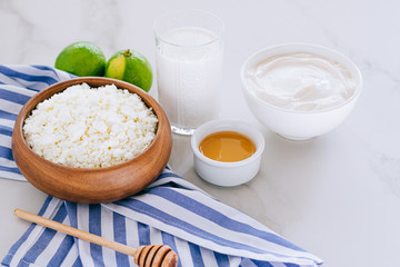 Healthy breakfast of cottage cheese with sour cream, honey and lime on a marble table