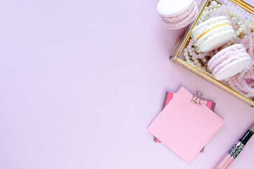 Fashion blogger workspace with laptop and female accessory, cosmetics products on pale pink table. Sweets, donuts, macaroons and gifts for the holiday Valentine's Day. flat lay, top view