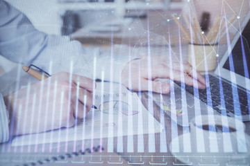 Multi exposure of stock market graph with man working on laptop on background. Concept of financial analysis.