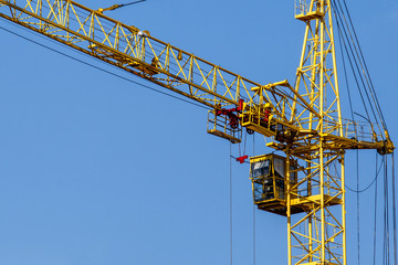 Construction site background. Hoisting cranes and new multi-storey buildings. I.ndustrial background.Building construction site work against blue sky