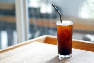 Iced americano - A glass of black coffee on table and copy space, The style of coffee prepared by brewing espresso and mixed with water, Refreshing summer drink concept.