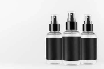 Transparent spray bottles for cosmetics product with black blank label on white background, mock up for branding, advertising, presentation, design.