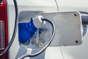 Close up on a charge port of electric car with plugged connector
