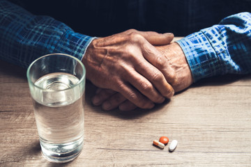 Many multi-colored pills in a Senior's hands
