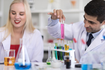 Male scientists and white female scientists are experimenting with chemicals in the laboratory.