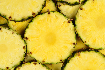 Pineapple juicy yellow slices background. Top view.