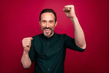 Naklejka premium Photo of crazy ecstatic overjoyed cheerful man making fists smiling toothily grimacing in happiness isolated vivid color background