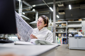 Woman lab technician sitting at table with carbon mesh