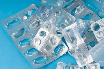 medical blisters packs opened and empty without pills top view on blue background