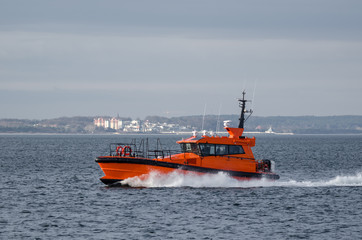 Fototapeta premium PILOT BOAT - Orange auxiliary boat on the water