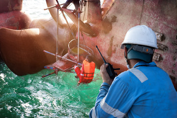 stevedore foreman takes control over walkie talkie to working safety of the shaft of the propeller...