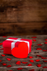 Valentine's day greeting card for love with red heart shape and gift box on wooden background