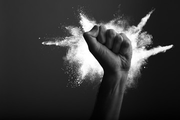 Raised clenched fist with white powder explosion, power, protest concept