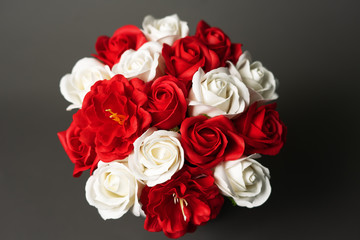 Flowers in bloom: Bouquet of red and white roses on a gray background.