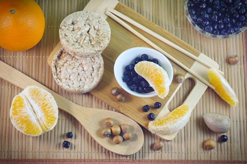 Flatley concept healthy food five grain loaves avocado apples chokeberry orange slices nuts on a wooden bamboo background