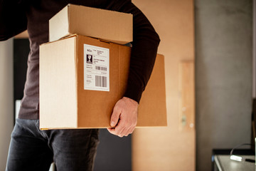 Young man carrying packages for shipment	