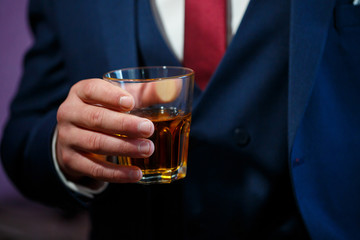 A man in a suit with a glass in his hands