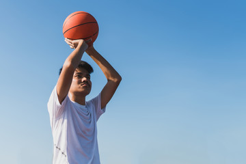 Young man practicing playing basketball