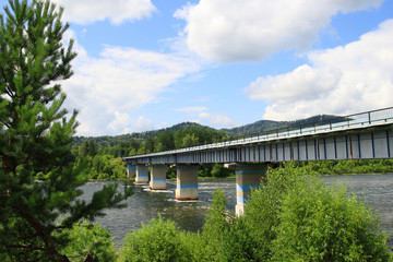 Bridge over the Biya river on a Sunny summer day in the Altai mountains in Russia