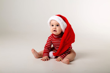 baby in a red bodysuit and Santa hat on a white background