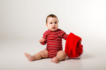 baby in a red bodysuit and Santa hat on a white background