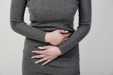 frau mit baus chmerzen regelschmerzen unterleibsschmerzen stehend hält sich bauch