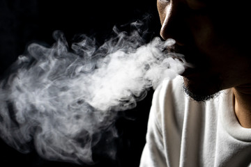 The man smoked From cigarettes or electric cigarettes or marijuana In the black background