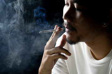 Asian men are smoking in a black background.