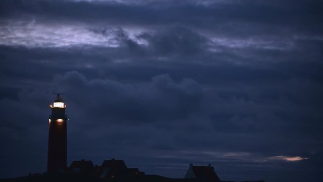 Eierland Lighthouse with light of lantern shining over the Wadden Sea at night on the Dutch island of Texel, West Frisian Islands, North Holland, the Netherlands