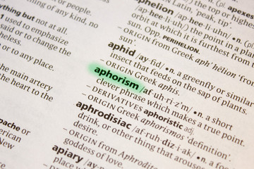 Naklejka premium Aphorism word or phrase in a dictionary.