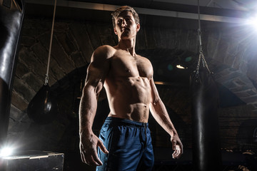 Fototapeta na wymiar Fit muscular bodybuilder man posing on dark background