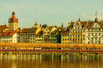 Chapel Bridge With Flowers and Luxury Hotel in City of Lucerne and Reuss River in Switzerland.
