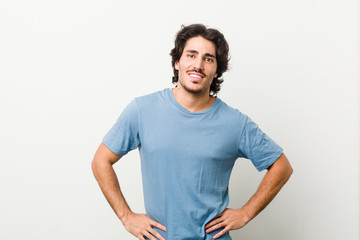 Obraz premium Young handsome man against a white background confident keeping hands on hips.